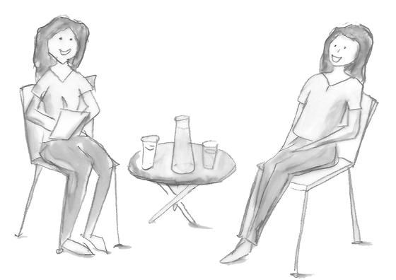 Therapeutin und erwachsene Klientin sitzen sich entspannt gegenüber, besprechen das Ziel der kinesiologischen Behandlung und klären Zusammenhänge im persönlichen Thema der Klientin